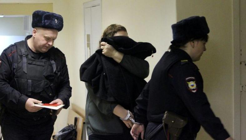 полиция надевает наручники. мошенничества осужденных. наручники решетка. 2022. преступник в суде.