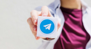Женщина держит в руке логотип Telegram.