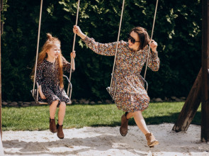 мама с дочкой качаются на качелях