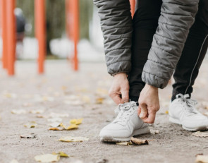 парень завязывает шнурок