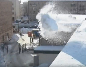 снег с крыши убирают