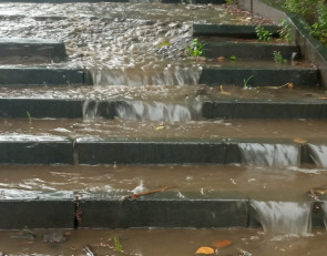 Вода течет по тротуару