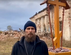 священник на фоне храма