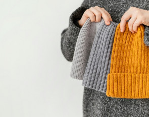 девушка держит шапки