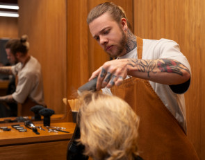 мужчина-парикмахер делает стрижку