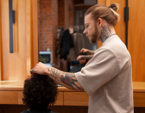 мужчина-парикмахер делает стрижку