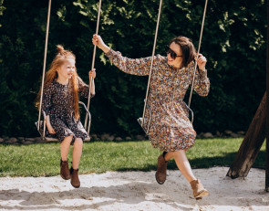 мама с дочкой качаются на качелях