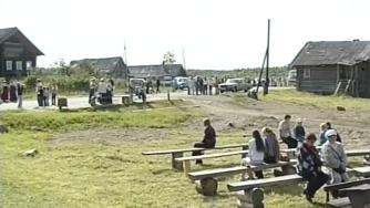 люди сидят на скамейках в деревне в Карелии