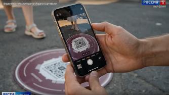 смартфон снимает куар-код на крышке люка