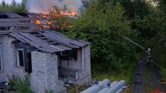 пожарные тушат горящее кирпичное здание