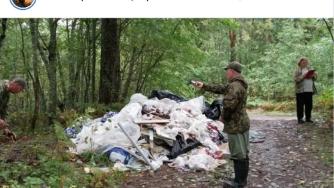 люди стоят у свалки в лесу