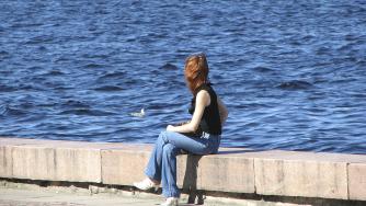 Одинокая девушка грустит у воды