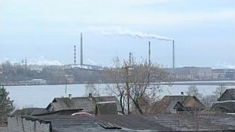 трубы завода, озеро, крыши домов