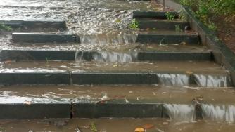 Вода течет по тротуару