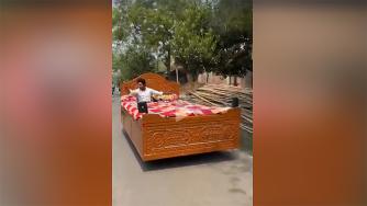Мужчина в Индии едет по дороге на самодельной "автокровати".