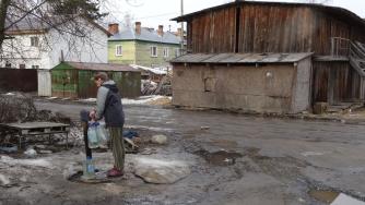 Женщина набирает воду из колонки