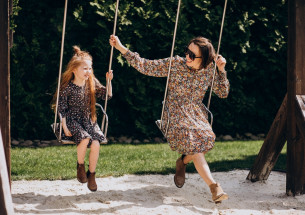 мама с дочкой качаются на качелях