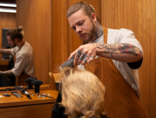 мужчина-парикмахер делает стрижку