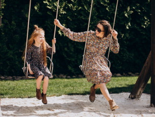 мама с дочкой качаются на качелях