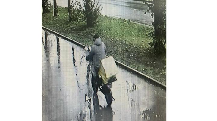 человек на электровелосипеде едет по тротуару