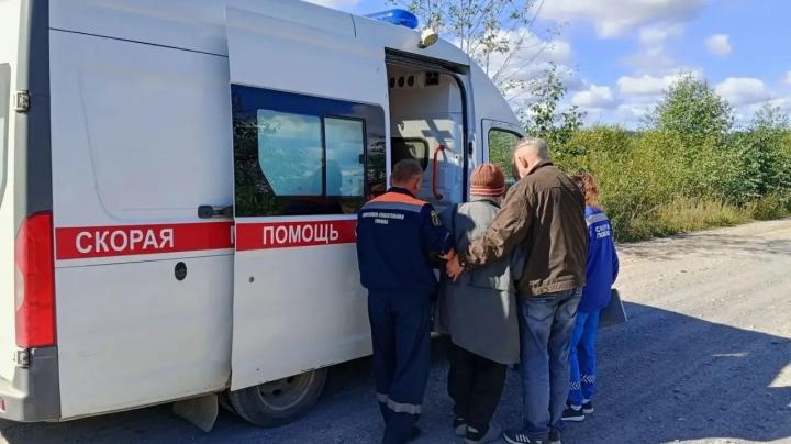 спасатели передают пожилую женщину медикам