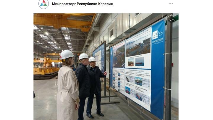 три человека стоят у стенда на заводе