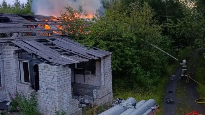 пожарные тушат горящее кирпичное здание