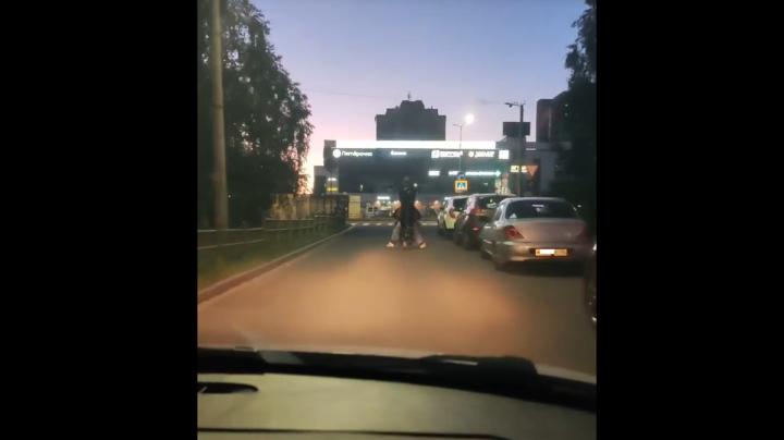 трое подростков на одном транспортном средстве едут по улице
