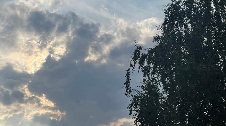 солнце пробивается сквозь тучи на августовском небе