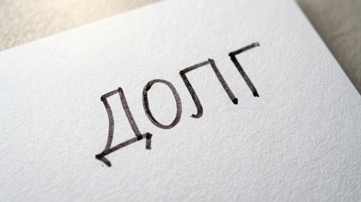 слово "долг" на белом листе бумаги