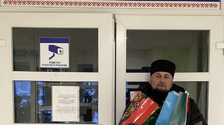 священник с подарками на крыльце больницы