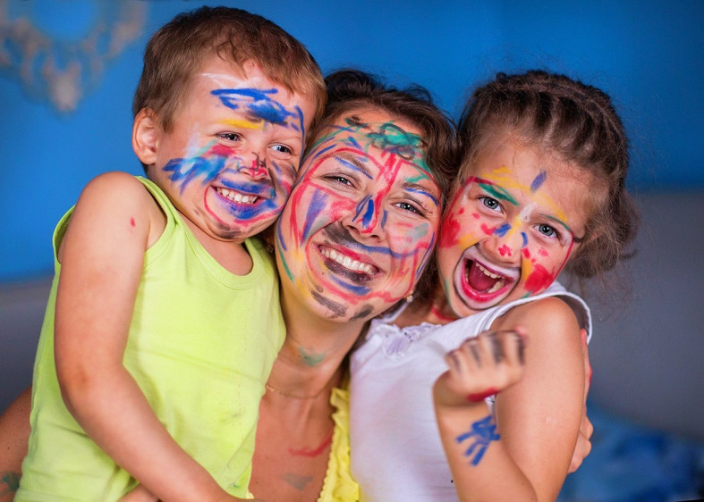 женщина с двумя детьми с разрисованными лицами