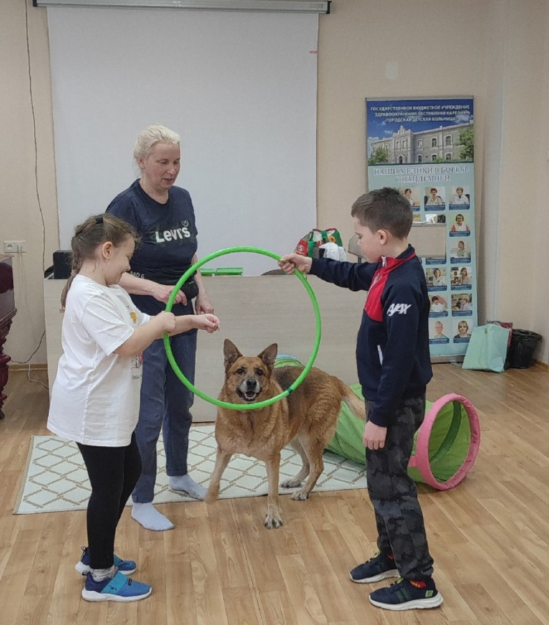 мальчик и девочка играют с собакой