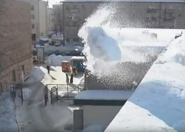 снег с крыши убирают