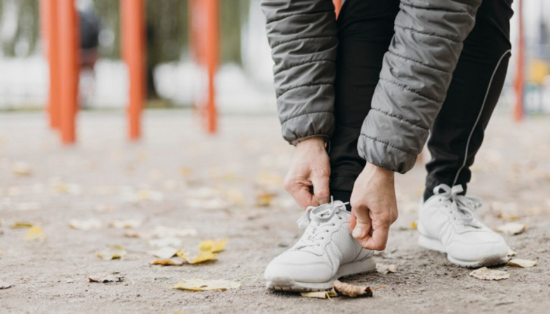 парень завязывает шнурок