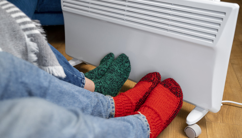 Люди греются у радиатора