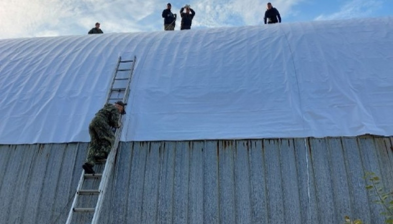 Кроют крышу ангара