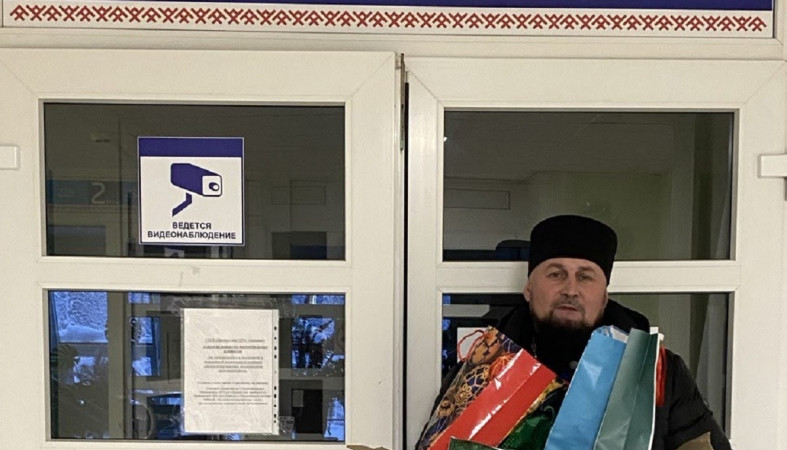 священник с подарками на крыльце больницы