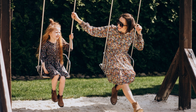 мама с дочкой качаются на качелях