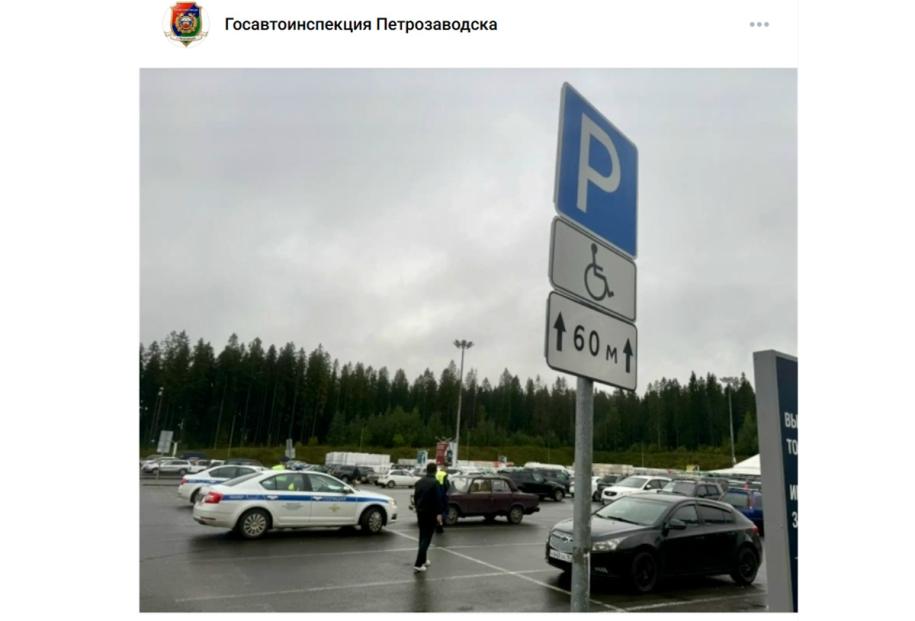 полицейская машина на парковке рядом со знаком инвалид