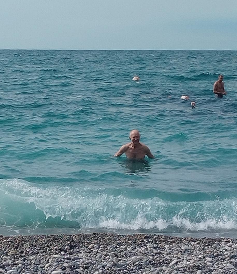мужчина купается в море