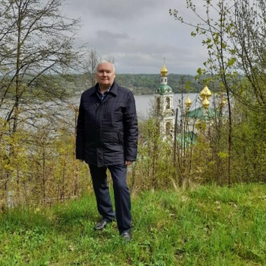 мужчина стоит на фоне реки и храма